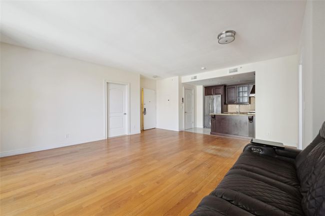 Living area with visible vents, light wood-style flooring, and baseboards | Image 4
