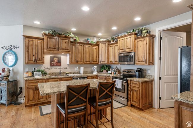 Kitchen with appliances with stainless steel finishes, light wood-style floors, brown cabinets, and recessed lighting | Image 11
