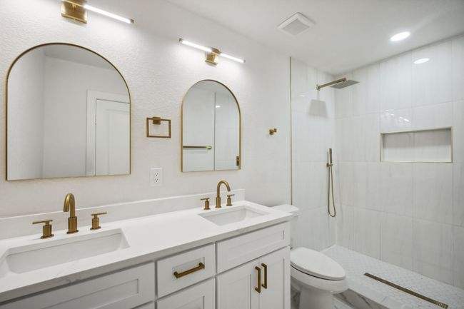 Bathroom featuring toilet, double vanity, a tile shower, and recessed lighting | Image 22