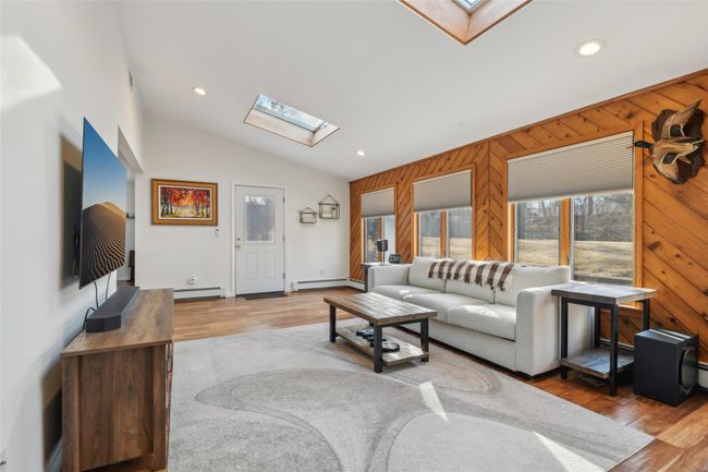 Living room with wooden walls, wood finished floors, and a baseboard radiator | Image 5