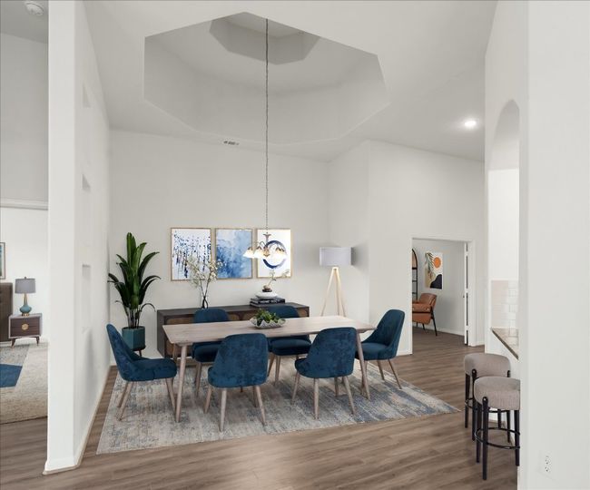 Dining space featuring wood finished floors, a raised ceiling, baseboards, a chandelier, and a high ceiling | Image 15