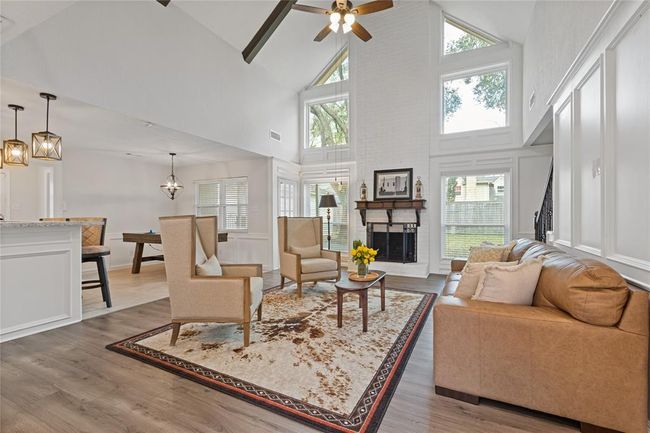 Light and bright family room with cozy fireplace. Arhitectural features include valuted ceiling with wood beams. | Image 11