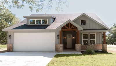 Craftsman inspired home featuring a front yard and a garage | Image 1