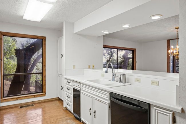 Kitchen with dishwasher, a textured ceiling, white cabinets, light countertops, and healthy amount of natural light | Image 20