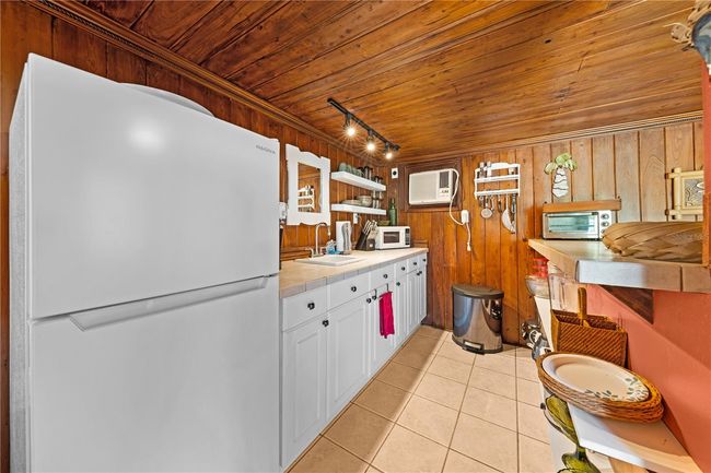 Cottage Interior - Kitchen with bar, refrigerator, sink and plenty of counter space. | Image 64