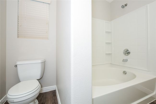 Full bath with a tub, wood finished floors, toilet, and baseboards | Image 11