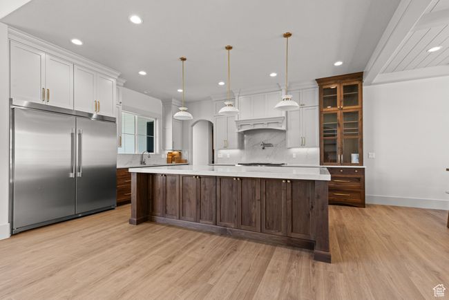 Kitchen with appliances with stainless steel finishes, backsplash, light countertops, light wood-style flooring, and recessed lighting | Image 4