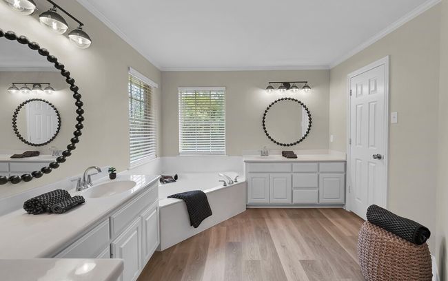 Large Primary Bathroom featuring a garden tub, wood finished floors, dual vanities | Image 22