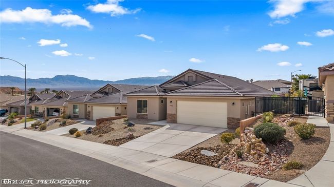 Ranch-style home featuring a mountain view, stucco siding, fence, a garage, and driveway | Image 60