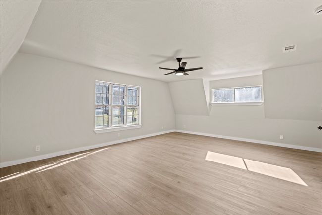 Spare room featuring a ceiling fan, light wood-type flooring, visible vents, and baseboards | Image 10