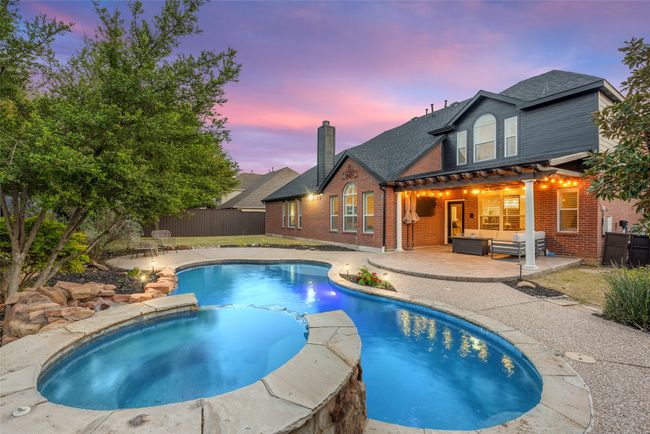 View of swimming pool with a patio area, outdoor lounge area, fence, and a pool with connected hot tub | Image 30