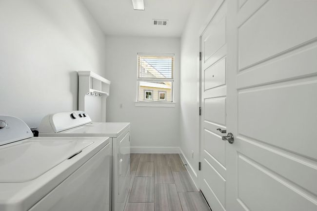 Laundry area with visible vents, baseboards, washer and dryer, wood finish floors, and laundry area | Image 15