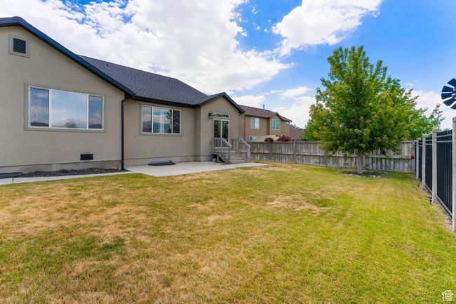 Fenced backyard with a patio | Image 37