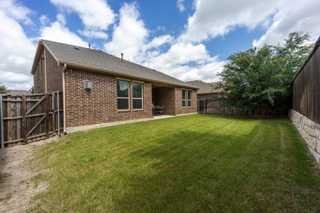 Back of property featuring brick siding, a fenced backyard, a patio, and a shingled roof | Image 21