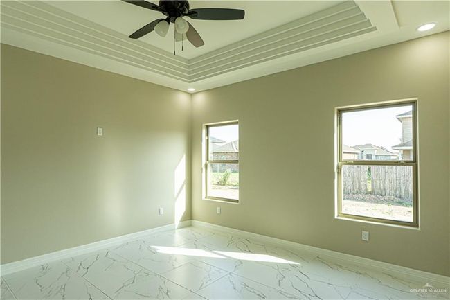 Empty room featuring marble finish floor, recessed lighting, a raised ceiling, ceiling fan, and baseboards | Image 26