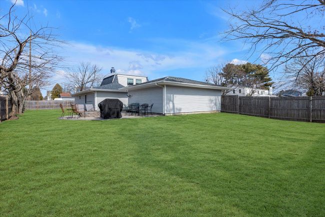 Rear view of house featuring a patio, a lawn, and a fenced backyard | Image 17
