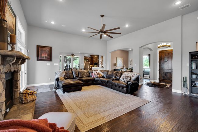Living room with ceiling fan, a fireplace, a wealth of natural light, and dark hardwood / wood-style floors | Image 6