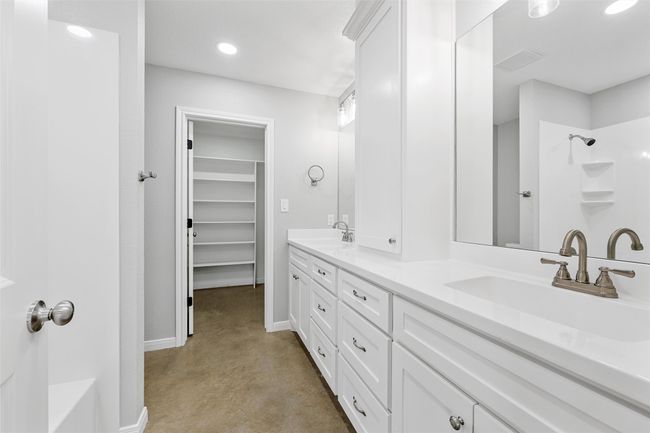 Bathroom with a shower, baseboards, concrete flooring, and a sink | Image 11