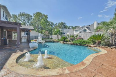 The pool is heated and features a tanning ledge, a relaxing hot tub, and striking water features. | Image 3