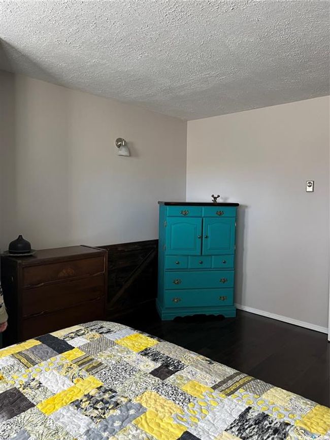 Bedroom with a textured ceiling and dark wood finished floors | Image 30