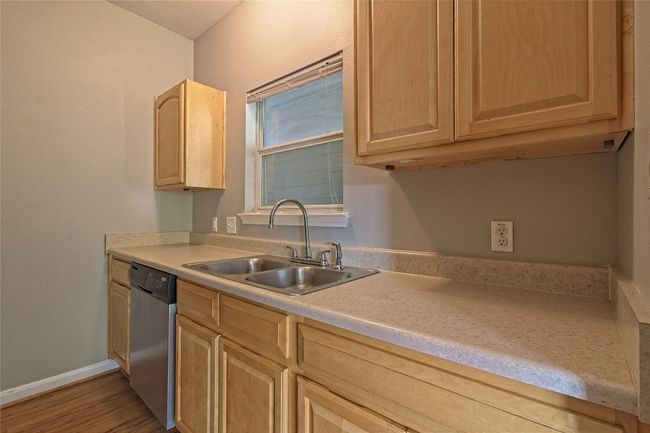Kitchen with light brown cabinetry, dishwasher, light countertops, and light wood-style flooring | Image 17
