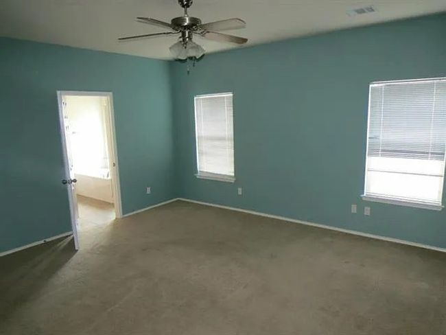 Carpeted empty room with a ceiling fan and baseboards | Image 7