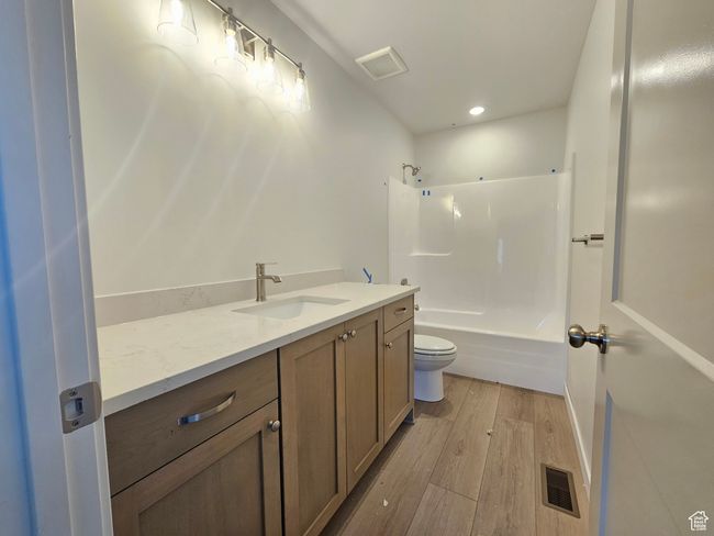 Bathroom with vanity, wood finished floors, shower / washtub combination, and recessed lighting | Image 23