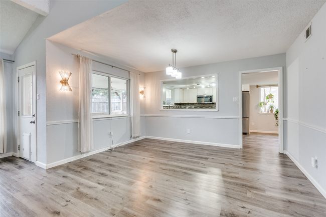 Unfurnished dining area with hardwood / wood-style flooring, a textured ceiling, and vaulted ceiling | Image 11