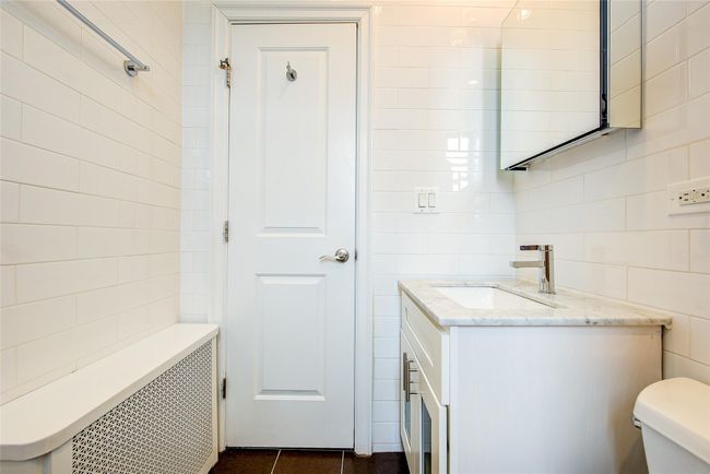 Bathroom featuring vanity, tile walls, toilet, tile patterned floors, and radiator heating unit | Image 10