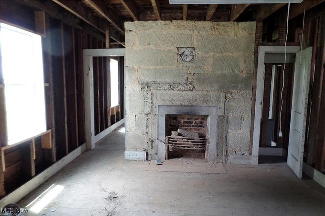 Unfurnished living room featuring a stone fireplace | Image 7