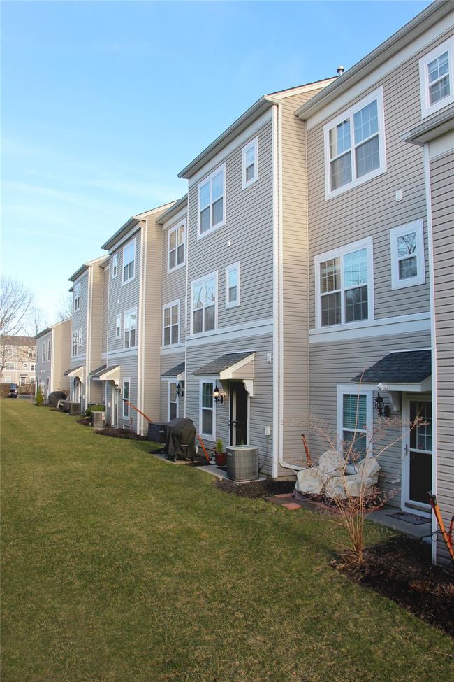 Back of property featuring a yard, a residential view, and central AC | Image 23