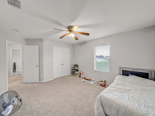 Carpeted bedroom with ceiling fan, baseboards, and a closet | Image 23