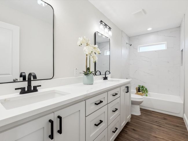 Bathroom featuring double vanity, toilet, wood finished floors, and a sink | Image 19