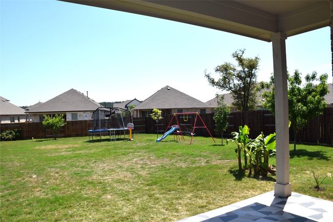 View of yard with a trampoline, a playground, and a patio area | Image 29