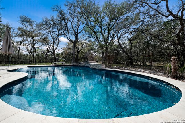 Fenced in, heated pool, with water features | Image 28