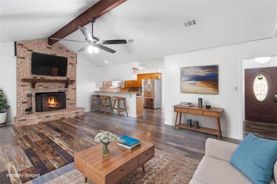 Warm & inviting family room with an open concept design that seamlessly connects the living area to the kitchen - creating a perfect flow for entertaining & everyday living. The rich vinyl flooring (replaced in 2017) adds a modern touch to this cozy & functional space. | Image 3