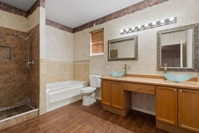 Full bathroom with tile shower, double vanity, and a bathtub | Image 23