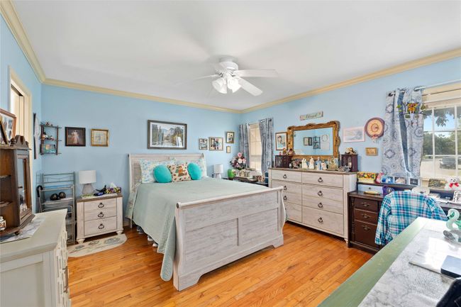 Primary bedroom located across the hall from the front bedroom which has a door to access additional parking area on side of home. | Image 25
