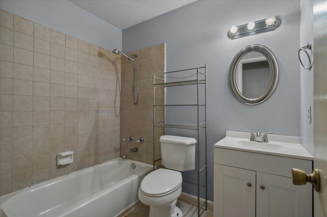 Full bath with shower / tub combination, vanity, and a textured ceiling | Image 6