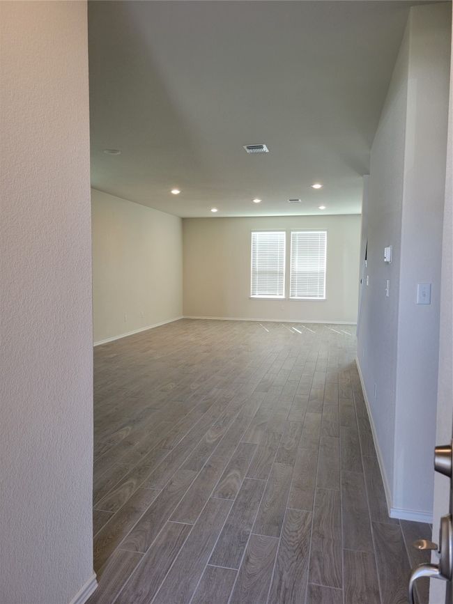 Unfurnished room featuring dark wood-style flooring, recessed lighting, baseboards, and visible vents | Image 9