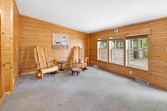 Living room boasts vaulted ceilings, beautiful tongue and groove and large sunny windows to the deck | Image 7