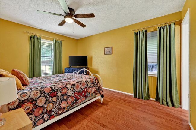 Bedroom with wood finished floors, a textured ceiling, and a ceiling fan | Image 16