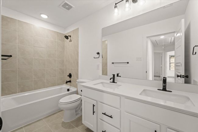Full bath with tile patterned floors, double vanity, shower / bathtub combination, and recessed lighting | Image 25