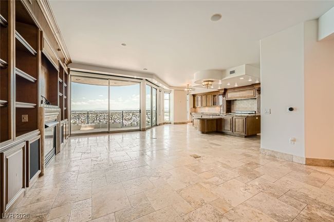 Unfurnished living room featuring stone tile floors, baseboards, recessed lighting, a chandelier, and expansive windows | Image 8