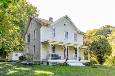 View of front of property featuring a front yard, a storage unit, and covered porch | Image 2