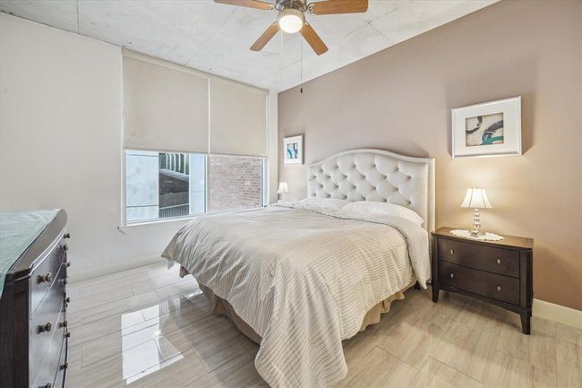 Generously sized primary suite (approx. 14x12) with large windows and elegant tile flooring, offering a bright and sophisticated retreat. | Image 9