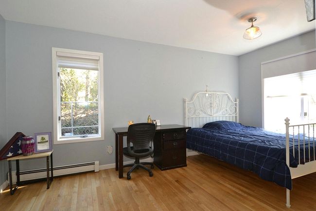 Bedroom with baseboards, light wood finished floors, and a baseboard radiator | Image 12