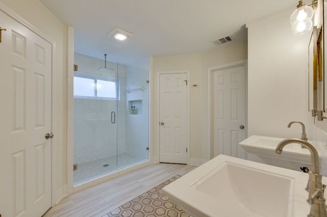 Primary Bathroom featuring walk-in shower, double pedestal sinks & custom closets | Image 15