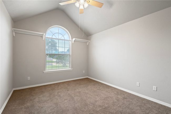 Carpeted spare room featuring ceiling fan, lofted ceiling, and baseboards | Image 8