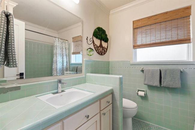Full bath # 2 features restored mid-century tile work with updated cabinet faces and fixtures. | Image 14